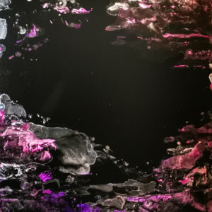 Alcohol ink painting in pink, purple and silver inks on black yupo paper